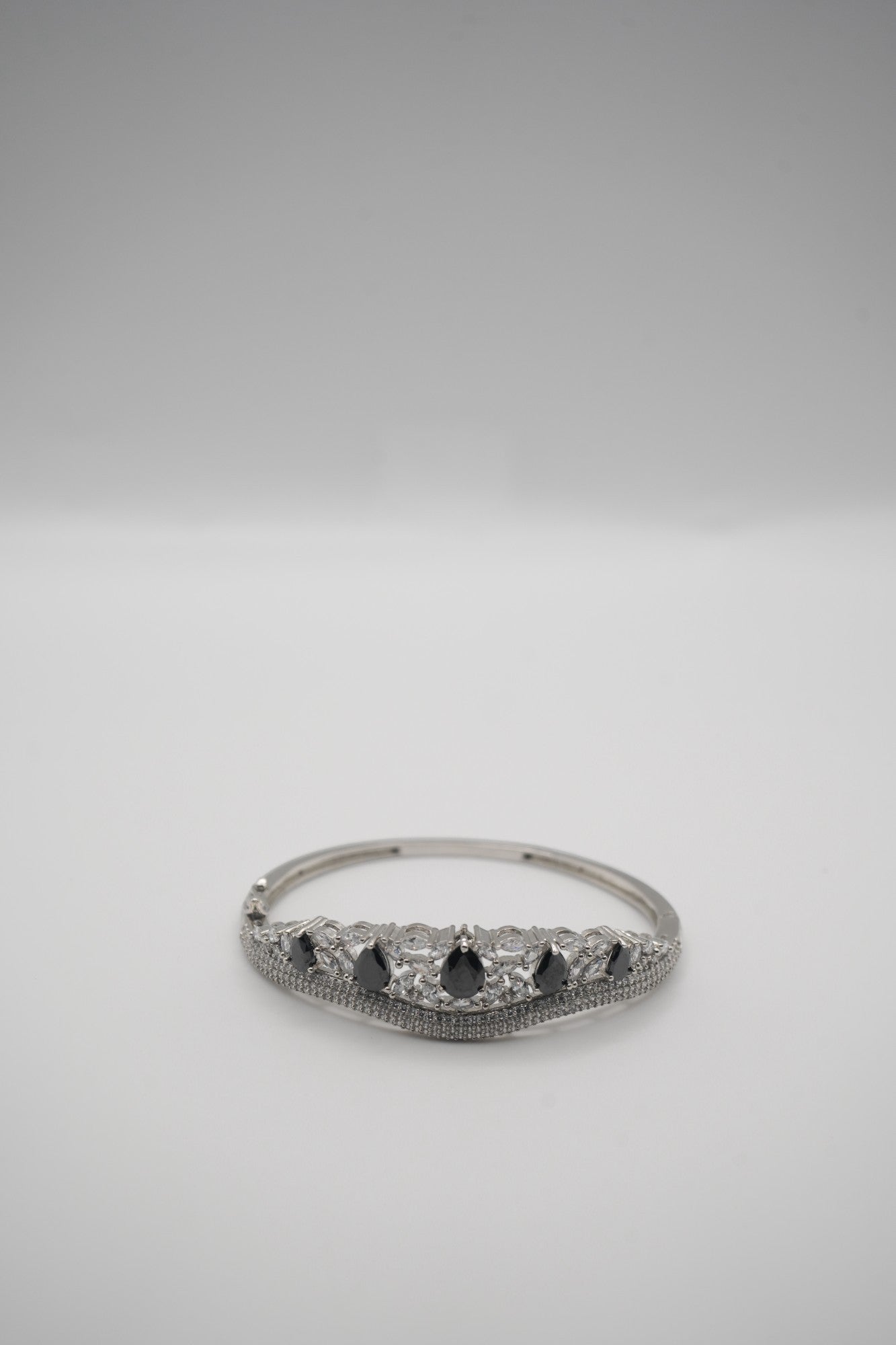 Elegant Silver Coated Bangle with Black Teardrop and Clear Crystal Accents