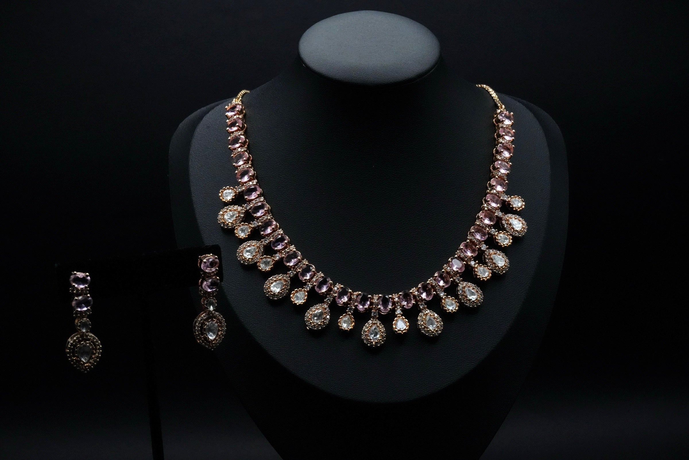 Stunning necklace set featuring stones in soft pink and clear hues, beautifully arranged in round and teardrop shapes.