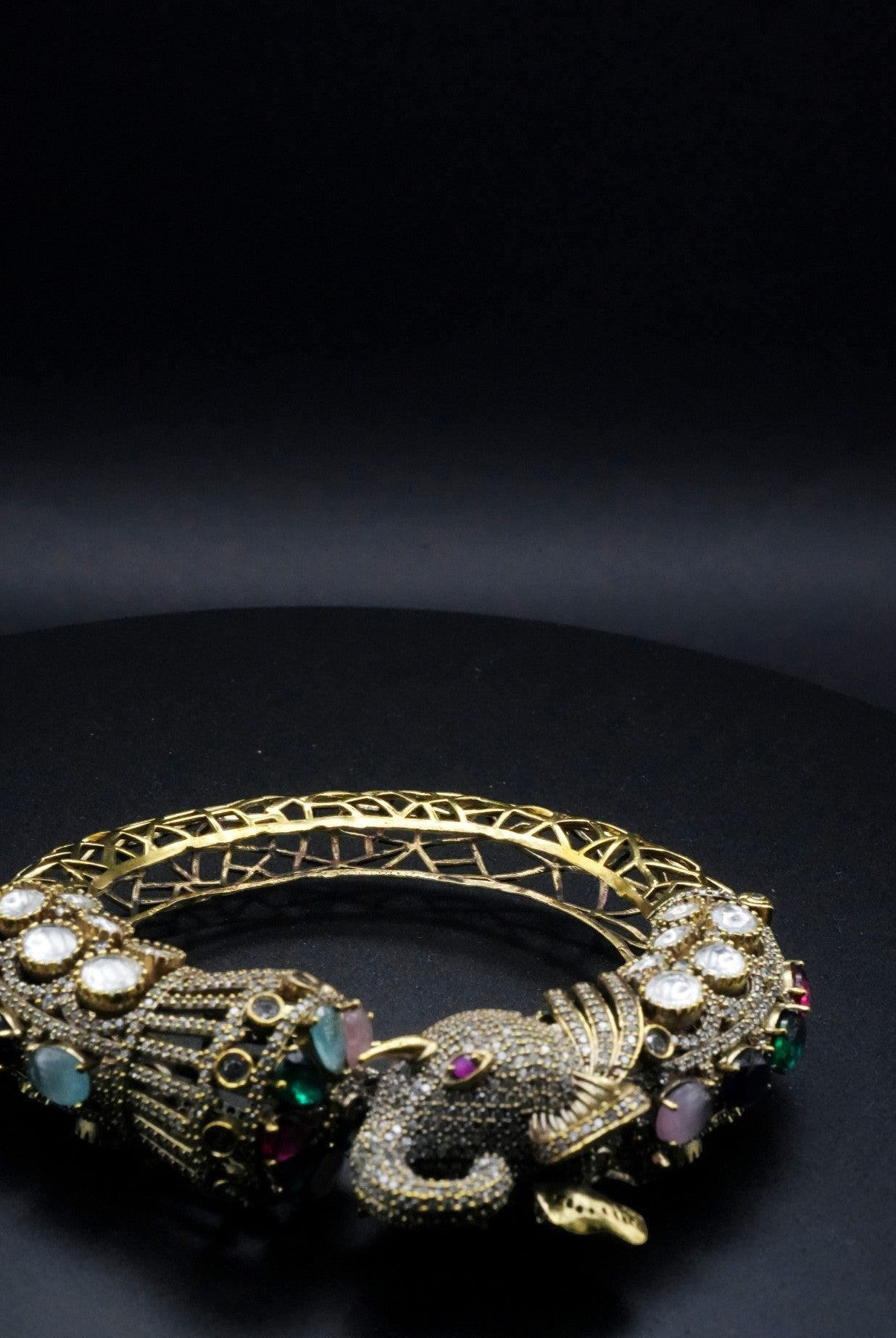 Luxurious Golden coated Serpent Bangle with Multi-Gem Accents